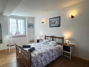 a bedroom with a bed and two tables and two windows at La Halte de la Hunière - Jardin - Central - Garage in Vimoutiers