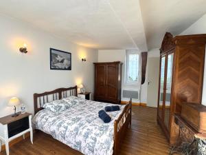 a bedroom with a bed and a wooden floor at La Halte de la Hunière - Jardin - Central - Garage in Vimoutiers +5 photos