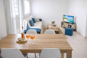 a living room with a wooden table with wine glasses at Abricotier à proximité des plages du sud in Rivière-Pilote