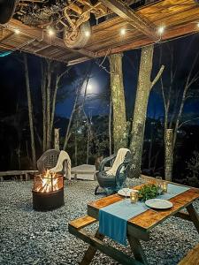 a patio with a table and a fire pit at Biciting Combi Love Glamping with Jacuzzi and Views in Mineral del Chico