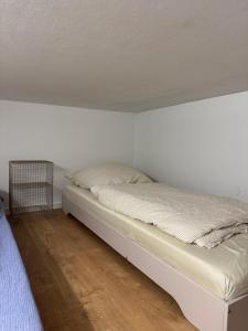 a bed in a room with a white wall at Hafenblick in Kiel