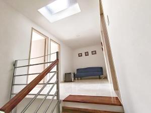 a staircase leading to a living room with a blue couch at Hospedaje en Montenegro Vivienda Turística Cafecito in Montenegro