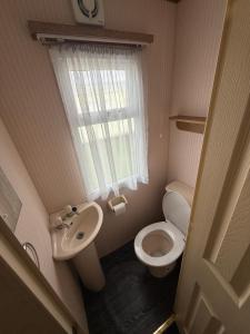 a small bathroom with a toilet and a sink at Holiday Home Arbroath in Arbroath