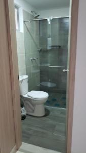 a bathroom with a toilet and a glass shower at Hospedaje en Montenegro Vivienda Turística Cafecito in Montenegro