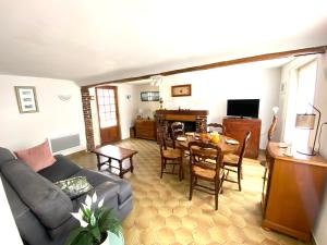 a living room with a couch and a table at La Halte de la Hunière - Jardin - Central - Garage in Vimoutiers