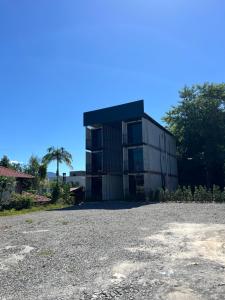a large black building with a gravel parking lot at Studio Garten Container in Joinville