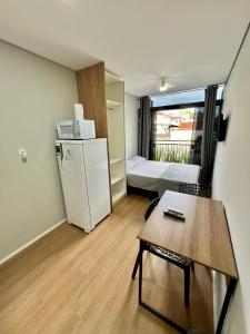 a small room with a refrigerator and a bed at Studio Garten Container in Joinville