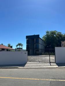 a building with a fence in front of a street at Studio Garten Container in Joinville +3 photos
