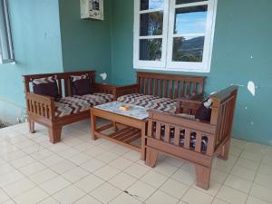 two wooden chairs and a table in a room at Villa Kay View in Sampal 2