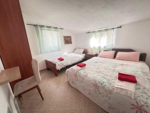 a bedroom with two beds and a chair in it at Bay Mola Aparts in Kotor