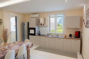 a kitchen with white cabinets and a table and a window at IVAN house - TERRASINI SICILIA in Terrasini