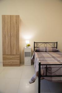 a bedroom with a bed and a wooden cabinet at IVAN house - TERRASINI SICILIA in Terrasini