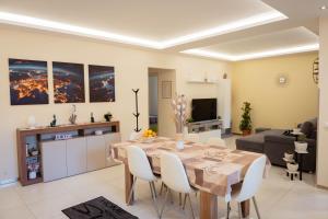 a living room with a dining room table with white chairs at IVAN house - TERRASINI SICILIA in Terrasini
