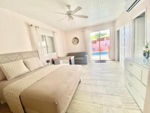 a bedroom with a bed with a ceiling fan at Villa avec piscine, vue sur mer, Rocher du Diamant in Sainte-Luce +13 photos