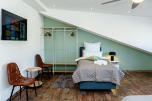 a bedroom with a bed and two chairs at Team Haus -6Zimmer 12Betten Parkplätze Grillen Terrasse Balkone schnell nach Augsburg und München in Mering