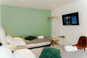 a room with two beds and a tv on the wall at Team Haus -6Zimmer 12Betten Parkplätze Grillen Terrasse Balkone schnell nach Augsburg und München in Mering