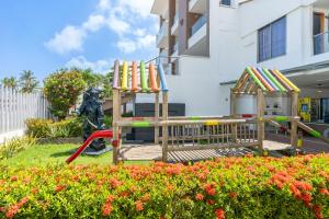 a playground in front of a building with flowers at Hotel La Fragata Coveñas in Coveñas