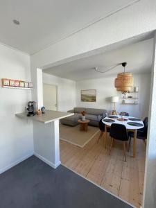 a kitchen and living room with a table and a couch at Hyggelig, lys og centralt lejlighed in Esbjerg