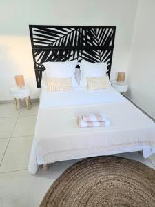 a bedroom with a large white bed with two chairs at Kaloukera in Trois-Rivières +17 photos