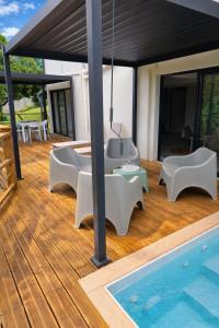 a wooden deck with a swimming pool next to a house at Kaloukera in Trois-Rivières