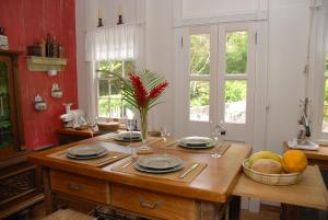 una cocina con una mesa de madera con platos y copas de vino en House On The Path, en Windwardside