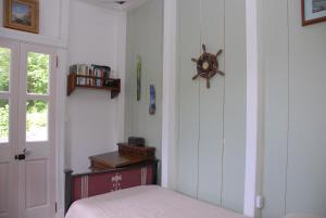 a bedroom with a bed and a clock on the wall at House On The Path in Windward Side