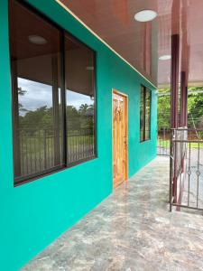 a room with a green wall and a door at Hospedaje Alejandra in Canoas