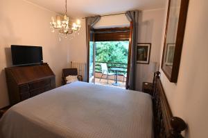 a bedroom with a bed and a television and a balcony at Villa Francesca BeB in Grumello del Monte