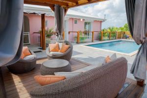 a patio with chairs and a swimming pool at Villa avec piscine, vue sur mer, Rocher du Diamant in Sainte-Luce