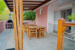 a patio with a wooden table and chairs at Villa avec piscine, vue sur mer, Rocher du Diamant in Sainte-Luce