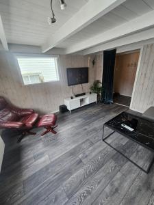 a living room with two chairs and a flat screen tv at Koselig enebolig i Sentrum in Egersund