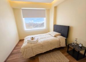 a bedroom with a bed with a window and a rug at Cusco Nest in Cusco
