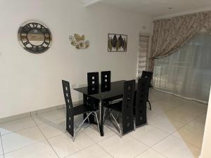 a dining room with a black table and chairs at Eagle Empire in Vereeniging