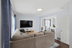 a living room with a couch and a flat screen tv at Modern Niagara Loft with Private Sunset Balcony Duplex in Niagara Falls
