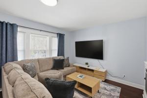 a living room with a couch and a flat screen tv at Modern Niagara Loft with Private Sunset Balcony Duplex in Niagara Falls +15 photos