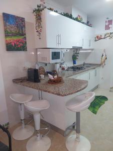 a kitchen with two stools and a counter with a microwave at Ketchs House in Ponte de Sor