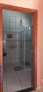 a glass door to a bathroom with a tile floor at Chalé casa na mata Jasmim in Guararema