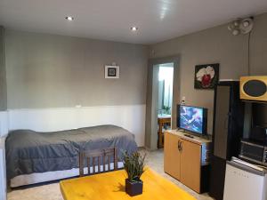 a bedroom with a bed and a table with a television at Dto III Temperley in Temperley