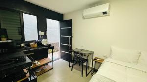 a bedroom with a bed and a desk and a bed and window at Chacara Stay in São Paulo