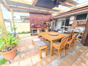 ein Holztisch und Stühle auf einer Terrasse in der Unterkunft Backyard Nook in South West Rocks + 10 Fotos