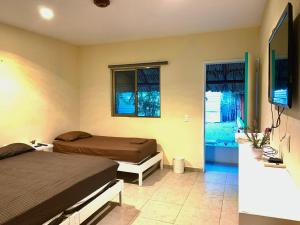 a bedroom with two beds and a television in it at Turquesa Bacalar Centro in Bacalar
