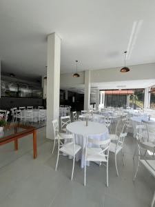 a dining room with white tables and white chairs at Castel Luz in Angelina