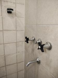 a shower with two knobs on a tile wall at Dormis H35 in Ataliva Roca