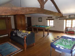a living room with a couch and a pool table at La Roseraie in Romagne