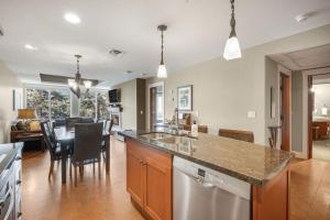 a kitchen and living room with a sink and a dishwasher at Star Suite -Luxurious condo with 3 fireplaces, and open Pool! in Canmore