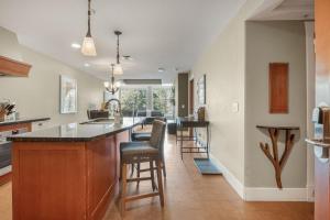 a kitchen with a large island with bar stools at Star Suite -Luxurious condo with 3 fireplaces, and open Pool! in Canmore