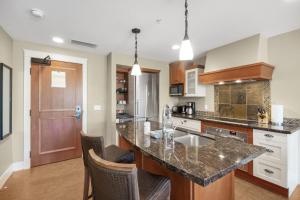 an open kitchen with a counter top and chairs at Star Suite -Luxurious condo with 3 fireplaces, and open Pool! in Canmore +51 photos