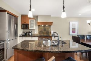 a kitchen with a sink and a counter top at Star Suite -Luxurious condo with 3 fireplaces, and open Pool! in Canmore