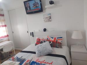 a bedroom with a bed with a tv on the wall at Ketchs House in Ponte de Sor