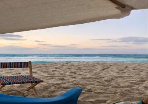 a beach with a chair and a beach umbrella at Sidi Rahal Playa beach in Casablanca